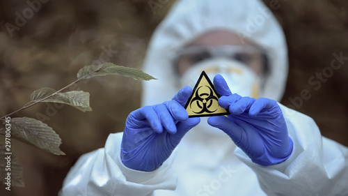 Biological hazard sign in researcher hands, health threat, virus danger, toxin photo