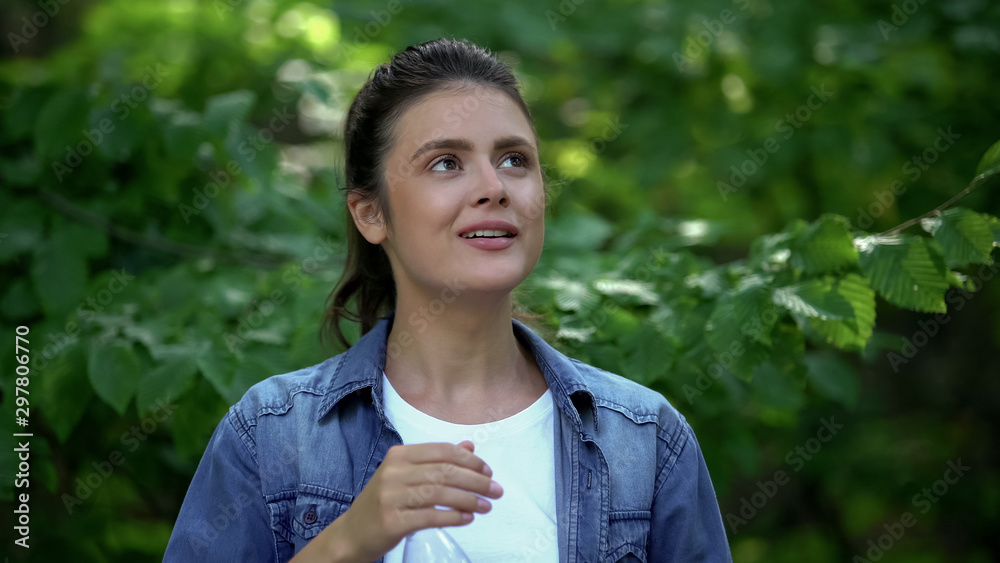 Inspired female looking around in forest, enjoying nature beauty, green tourism