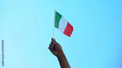 Person holding flag of Italy on sky background, patriotism, liberty, close-up