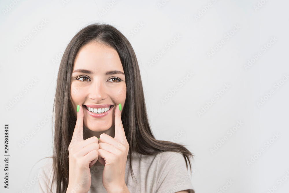 girl pointing healthy smile over grey background girl pointing healthy smile over grey background