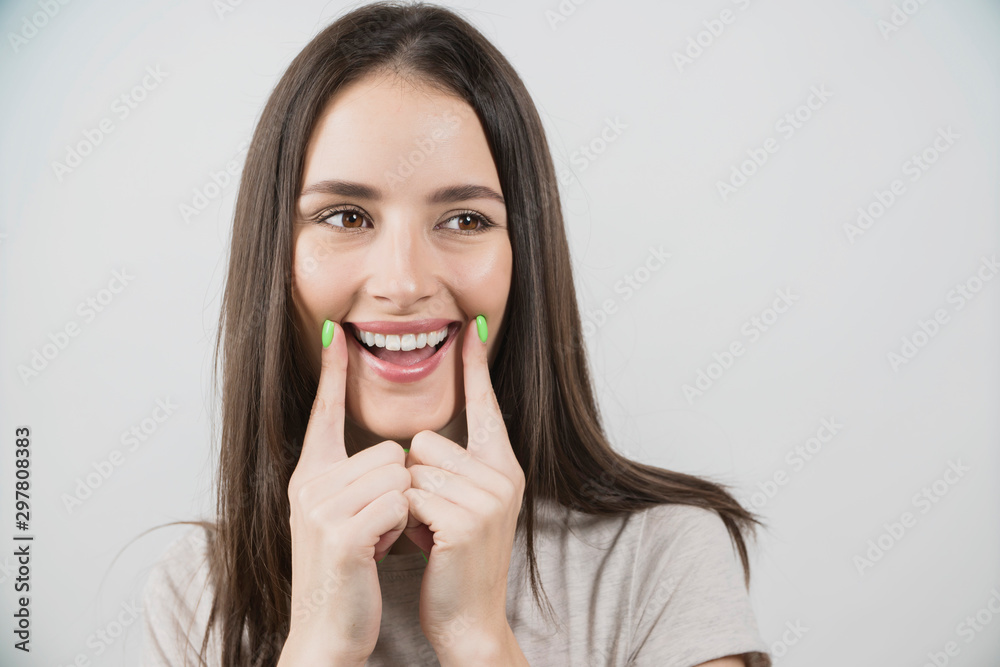 girl pointing healthy smile over grey background girl pointing healthy smile over grey background