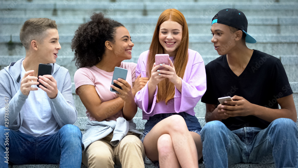 Obraz premium Cheerful red-haired student reading good news on smartphone, online lottery
