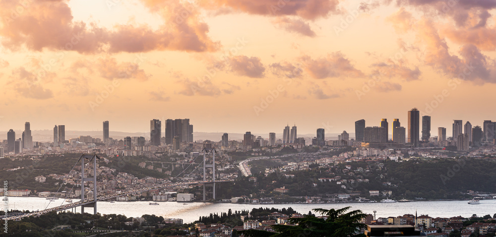 Panoramic Istanbul view and Bosphorus Bridge at sunset. City view and cloudy sky.