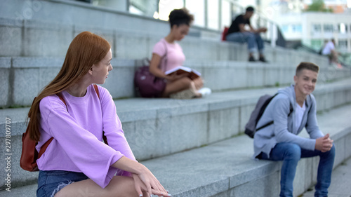 Canvastavla Red haired teen looking at male classmate smiling to girl, first feelings