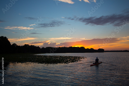 Daybreak at a central Florida lake with a kayaker rowing.