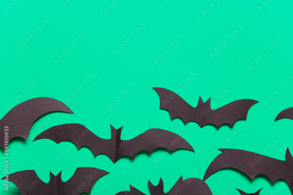 Fototapeta premium Halloween paper vampire bat decorations on a green background.