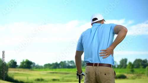 Male golf player feeling strong lower back pain after ball hitting, trauma