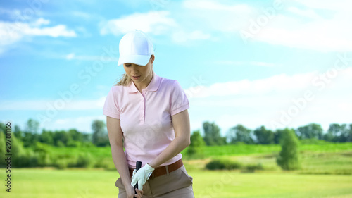 Female golfer ready to hit ball with club at meadow, training and hobby, sport