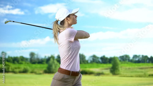 Woman playing golf in backswing position, upset about failed shot, loser concept