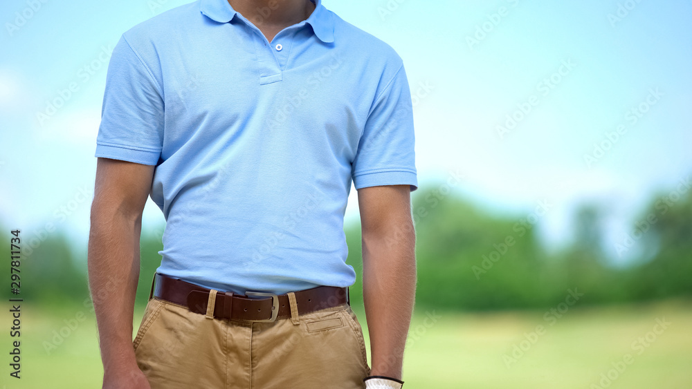 Athletic male golf player in sportswear posing on camera at course, elite hobby Athletic male golf player in sportswear posing on camera at course, elite hobby