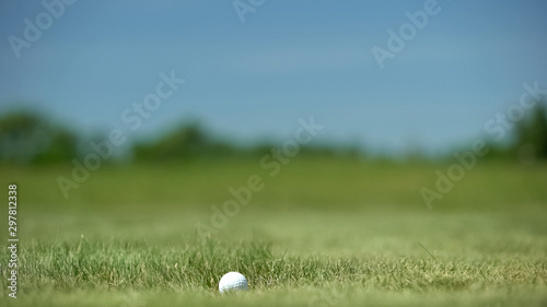 Golf ball on tee ready to be shot, sport equipment, luxury hobby and game