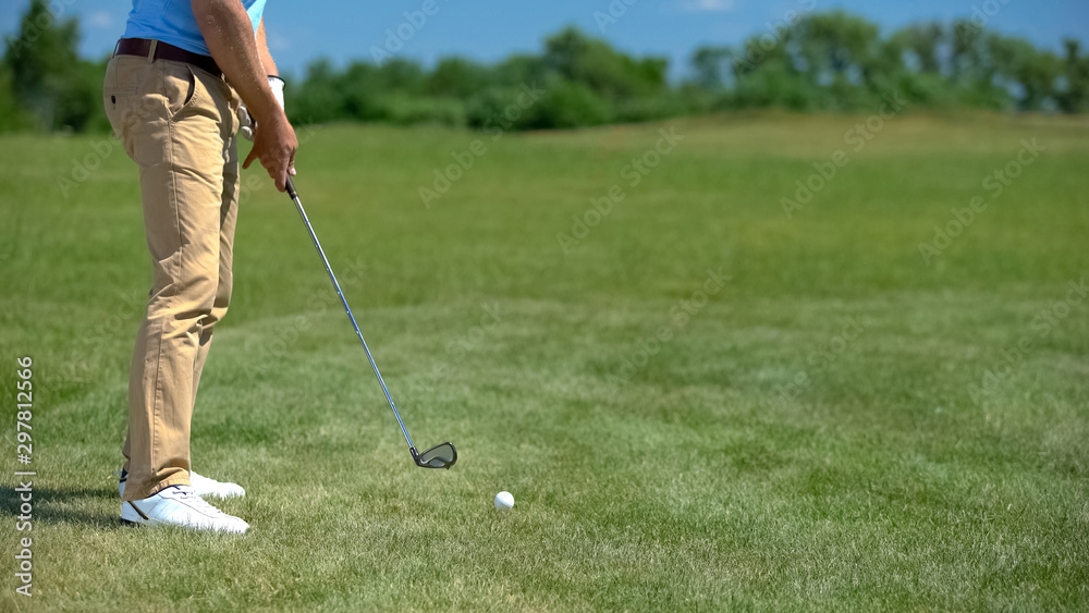 Fototapeta premium Professional golf player ready to hit ball, preparing for competition, sport