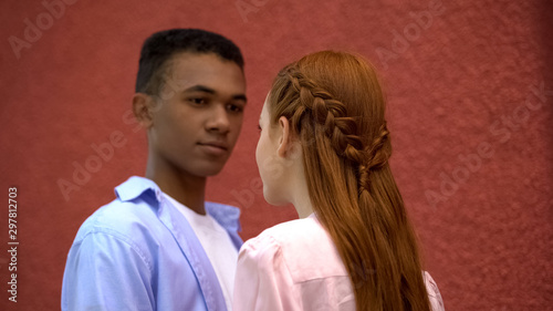 Teenagers couple looking at each other, beautiful hairstyle of red haired girl