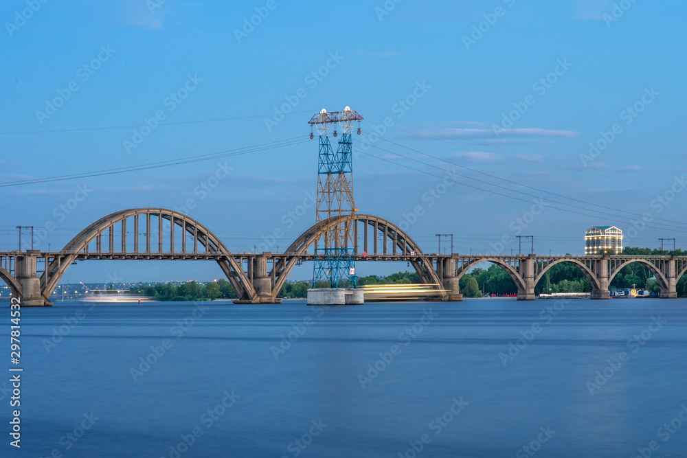 Picturesque landscape of the Ukrainian Dnipro city with old arch Railway Merefo-Kherson bridge across the Dniepr river in Ukraine.