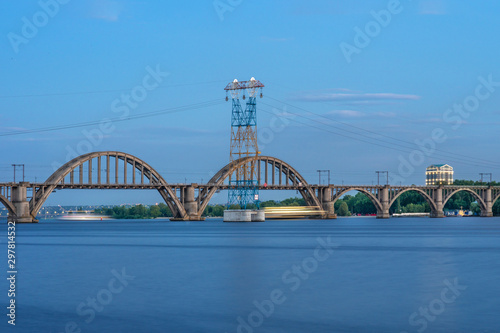 Picturesque landscape of the Ukrainian Dnipro city with old arch Railway Merefo-Kherson bridge across the Dniepr river in Ukraine.