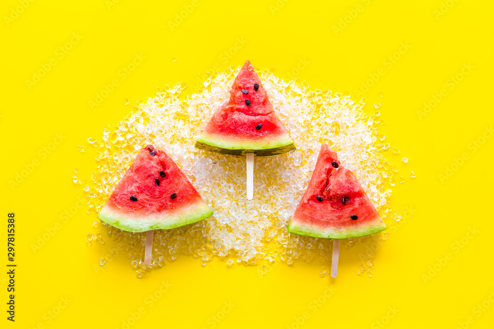 Fresh watermelon on stick with ice for fruit ice cream on yellow background top view Fresh watermelon on stick with ice for fruit ice cream on yellow background top view