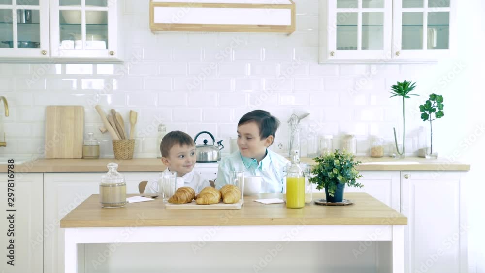 Portrait of two boys waiting for breakfast and having fun in the kitchen Portrait of two boys waiting for breakfast and having fun in the kitchen