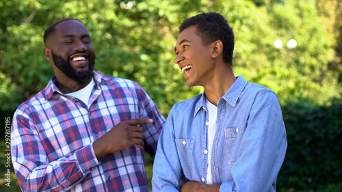 Tableau sur toile Afro-american young and adult brothers laughing having fun together, family
