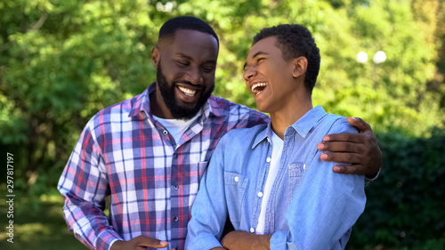 Photographie Young black man hugging younger brother laughing having fun together, family