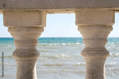 View of the rippling sea through two old pillars of the fence