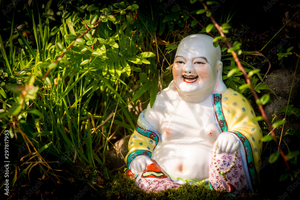 Smiling Buddha Hotey figurine in green grass