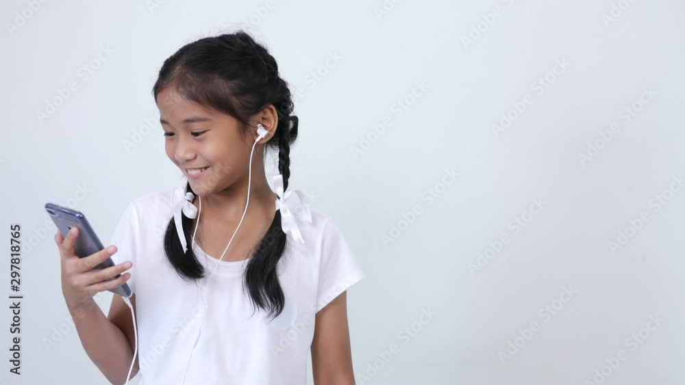 Girls wearing a white shirt, braid and tie a lovely white ribbon are using the internet on the smartphone and smile. The space of opposite side for placing advertising or banner. Girls wearing a white shirt, braid and tie a lovely white ribbon are using the internet on the smartphone and smile. The space of opposite side for placing advertising or banner.
