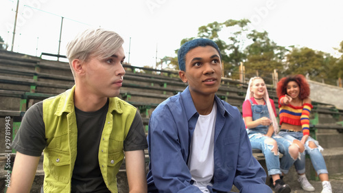 College students mocking male classmates with colored hair, teenage bullying