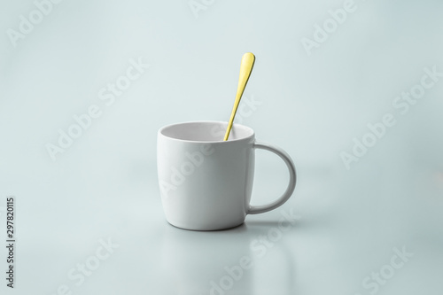 luxury white cup and gold spoon inside the cup with white background