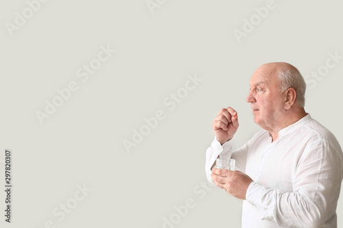 Elderly man taking medicine...