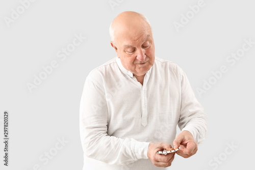 Elderly man with pills on l...