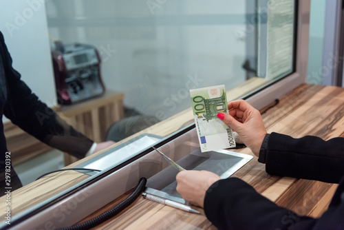 Money exchange concept / Female hand with money at cash desk. Currency exchange concept.