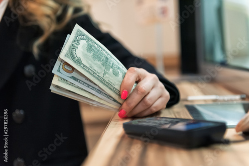 Money exchange concept / Female hand with money at cash desk. Currency exchange concept.