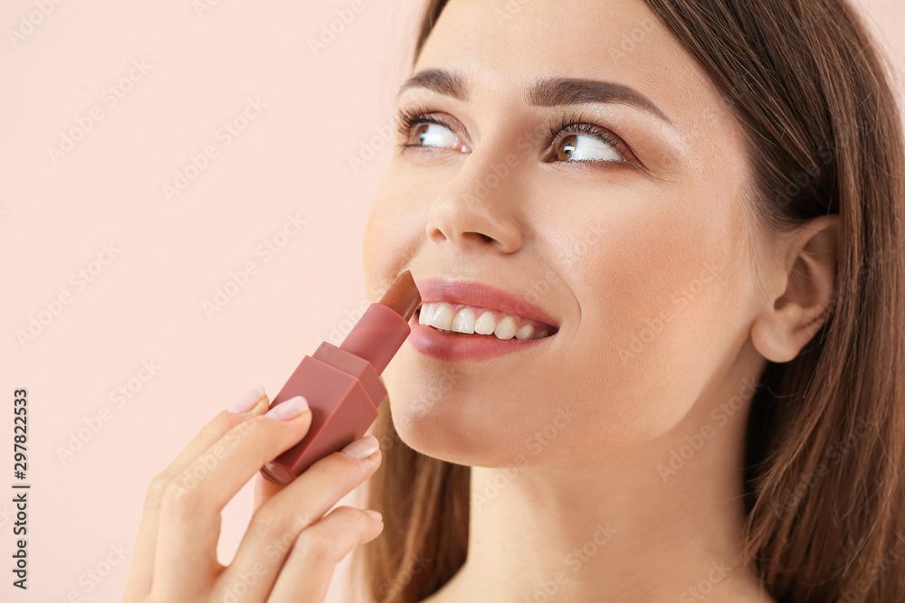 Beautiful young woman with lipstick on color background Beautiful young woman with lipstick on color background