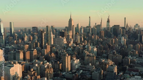 Flying backwards above Manhattan buildings, New York City at sunrise photo