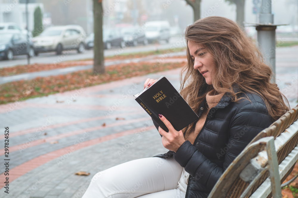 Fototapeta premium Women in outdoors reading Bible. Concept for faith, spirituality and religion