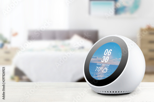 Obraz na płótnie Personal assistant alarmclock and loudspeaker on a white wooden shelf of a smart home bedroom