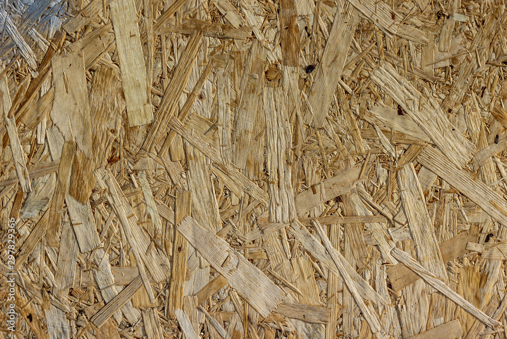 Closeup of a wood particle board with a stain of silver paint in the corner