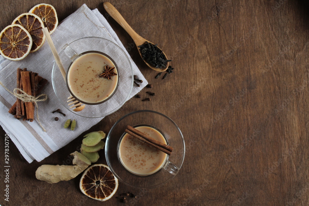 Masala chai tea on wooden background. Traditional Indian hot drink with spices. Top view, copy space.