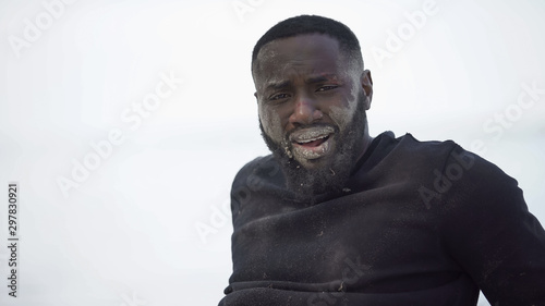 Billede på lærred Male survivor after natural disaster crying, looking in camera, hopelessness