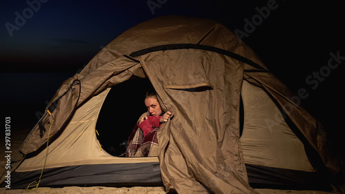 Frozen woman sitting in tent, bad accommodations in refugee camp, unhealthy