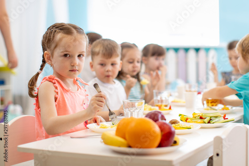 Kids have lunch in daycare. Children eat healthy food in kindergarten