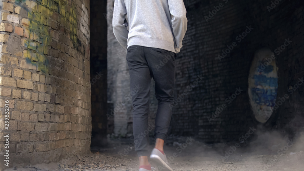 Unhappy high school student walking abandoned city building alone, puberty age Unhappy high school student walking abandoned city building alone, puberty age