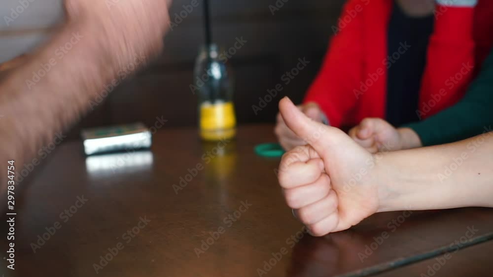 Group of people throws out fingers before board game.