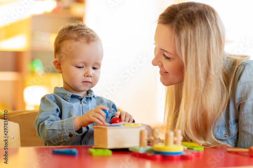 Woman and kid toddler playing logical toys at home