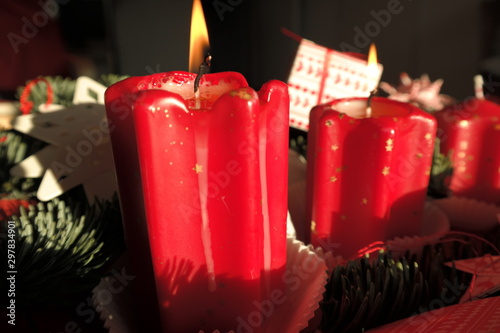 Red candles with flame, part of Christmas decoration. Good light, red color, Christmas time