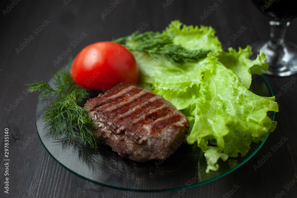 Grilled steak with vegetable salad and herbs. Concept for a tasty and healthy meal. Dark bakground Grilled steak with vegetable salad and herbs. Concept for a tasty and healthy meal. Dark bakground