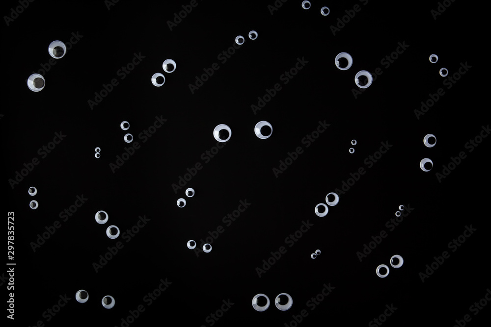 Funny face made from googly eyes organized on black background Funny face made from googly eyes organized on black background