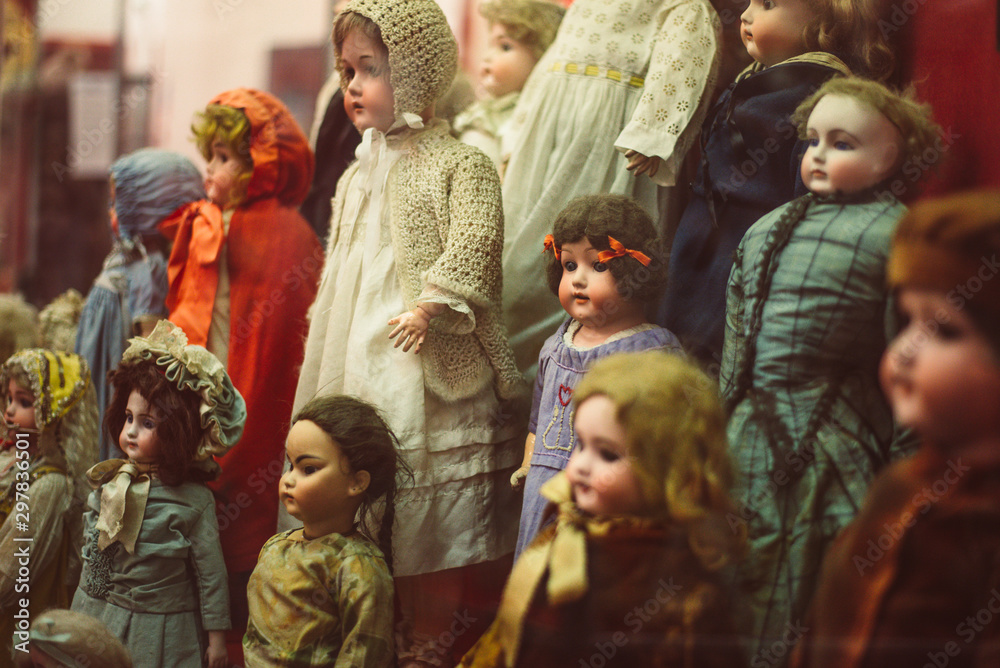 dużo róznych lalek. lalki są ubrane w sukienki. stare zabawki