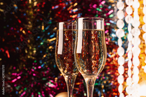 Champagne in glass goblets close-up on a sparkling festive background. New year christmas concept. Horizontal frame.