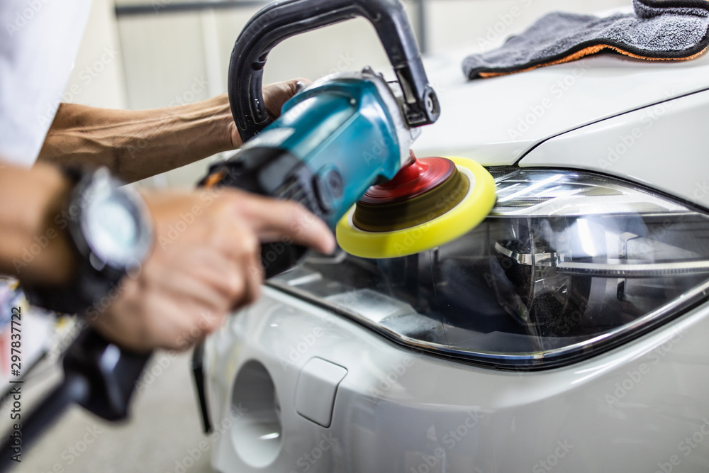Car detailing - Hands with orbital polisher in auto repair shop. Selective focus. Car detailing - Hands with orbital polisher in auto repair shop. Selective focus.